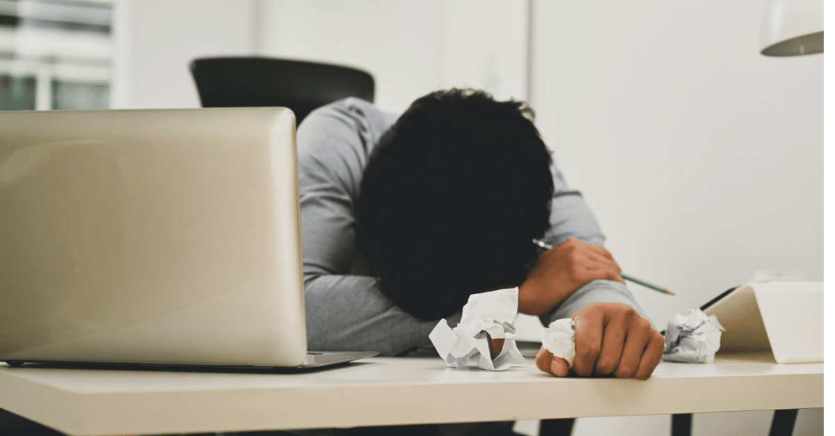 A man laying with his face on the desk