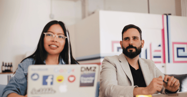 A woman and a man smiling at their office.