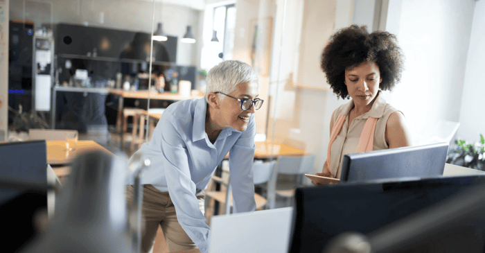 Two people smiling at the computer.